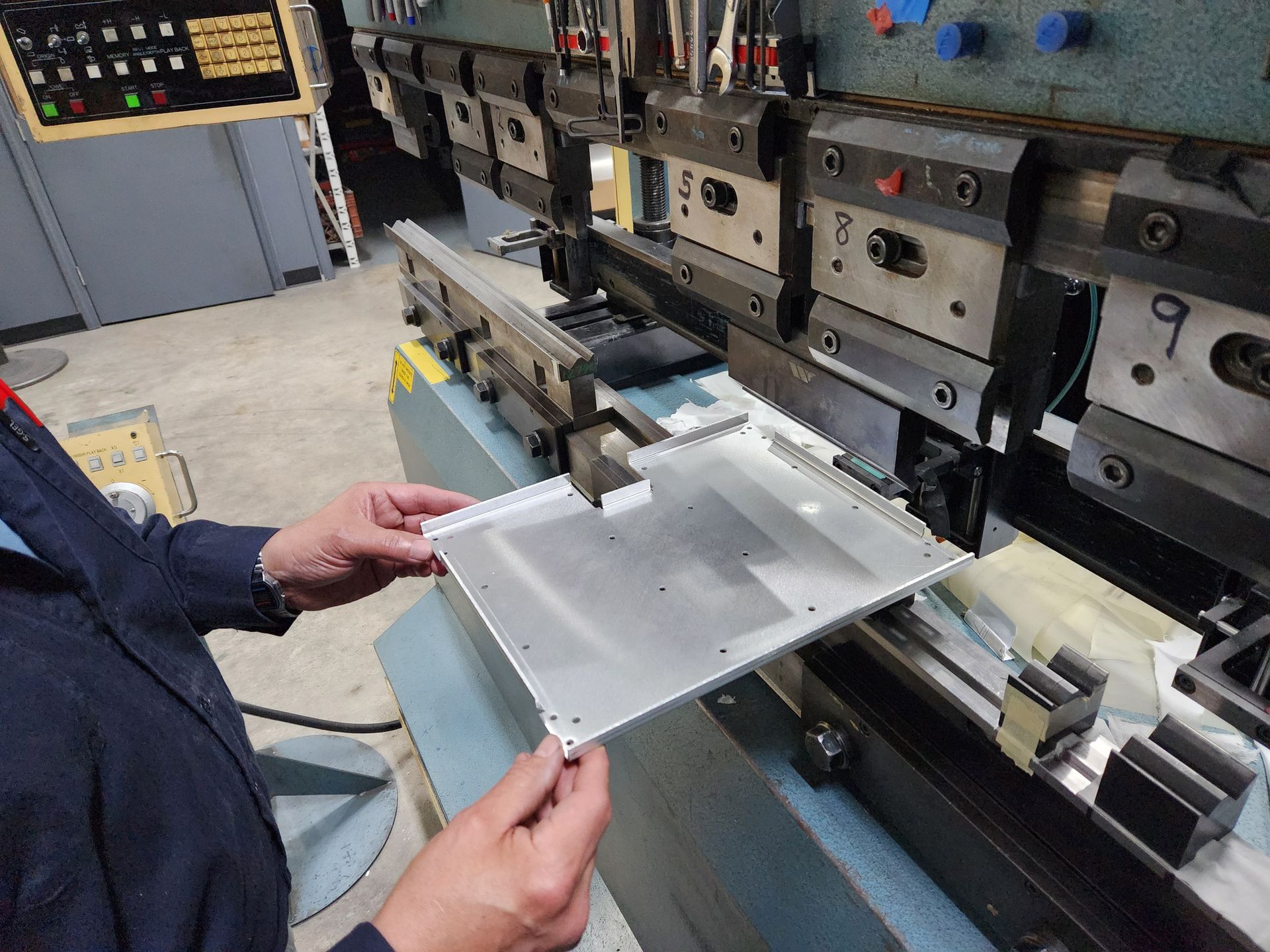 CNC press brake forming precision aluminum sheet metal component at AIM facility
